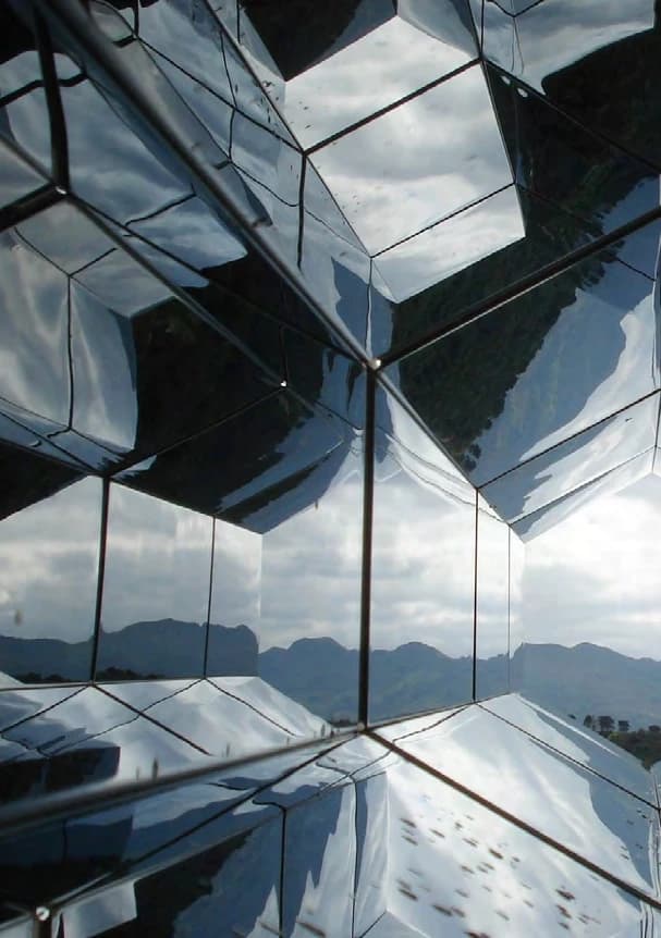 Glasfassade mit geometrischen Spiegelungen.